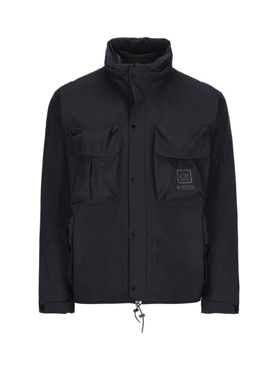 Giacca realizzata in poliammide di colore blu scuro, con maxi tasche sul petto con logo. 15CLOW007A 005967A888 C.P COMPANY 